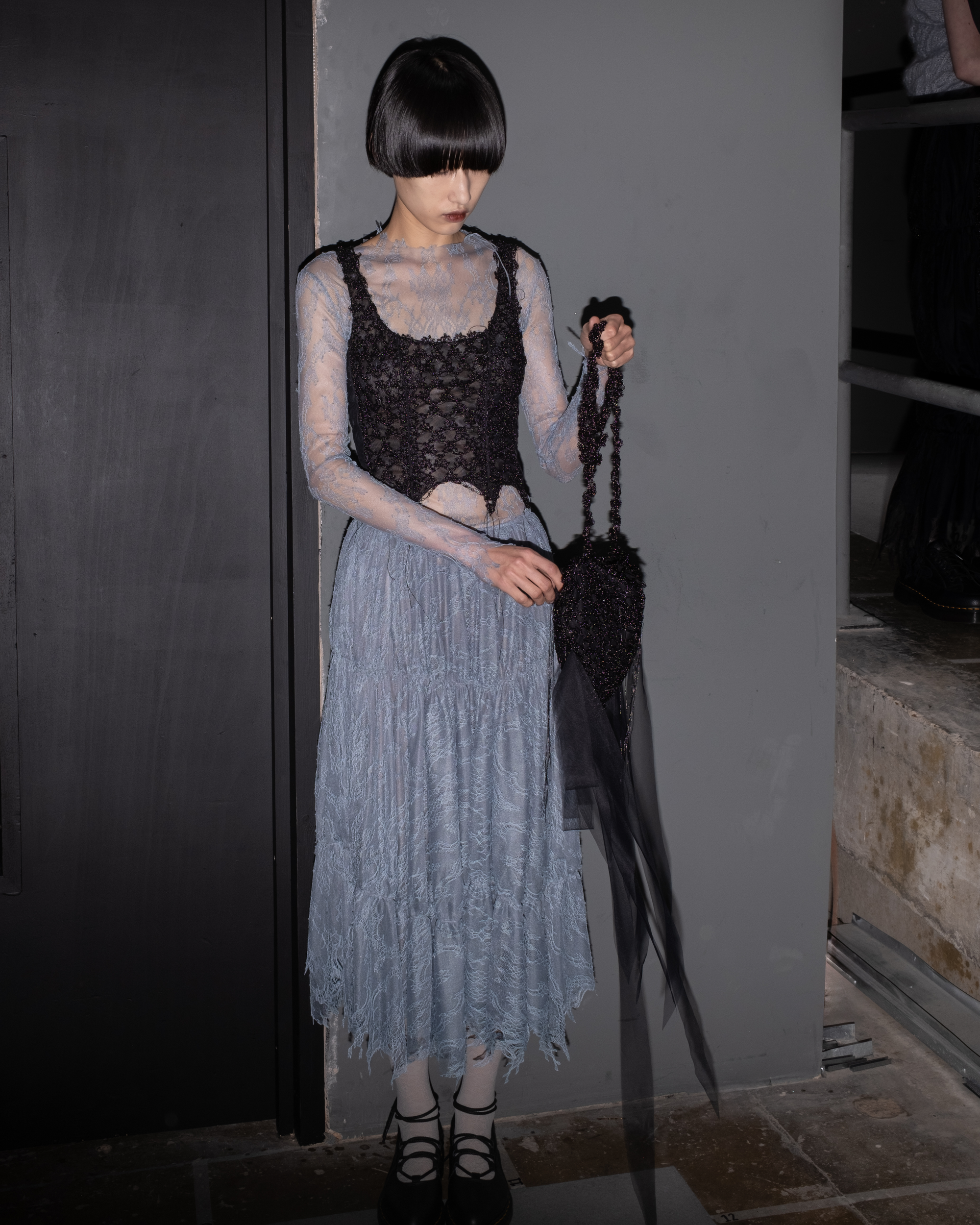 Black crochet heart bag shown styled as clutch with tulle ribbons trailing